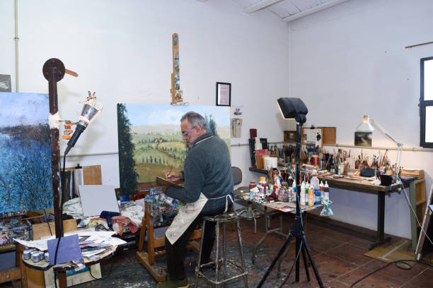 istock Painter artist painting a picture in the studio 933474700