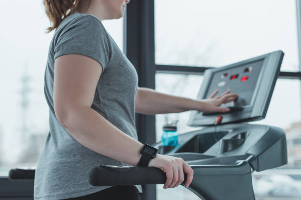 istock Curvy girl adjusting treadmill in gym 933478152