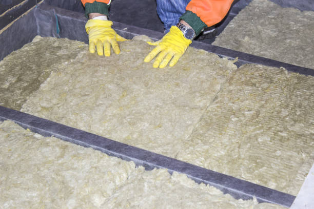 istock Builder hands wearing glove insulating wooden house with mineral wool 933479552