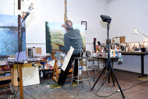 istock Painter artist painting a picture in the studio 933480034