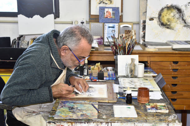 istock Painter artist painting a picture in the studio 933480160