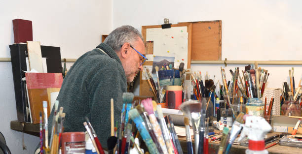 istock Painter artist painting a picture in the studio 933480448