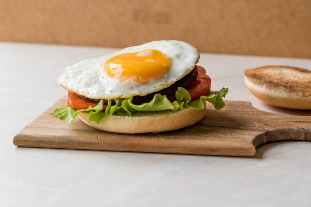 istock Open Hamburger with Egg, Lettuce and Tomatoes on Wooden Surface. 933488854