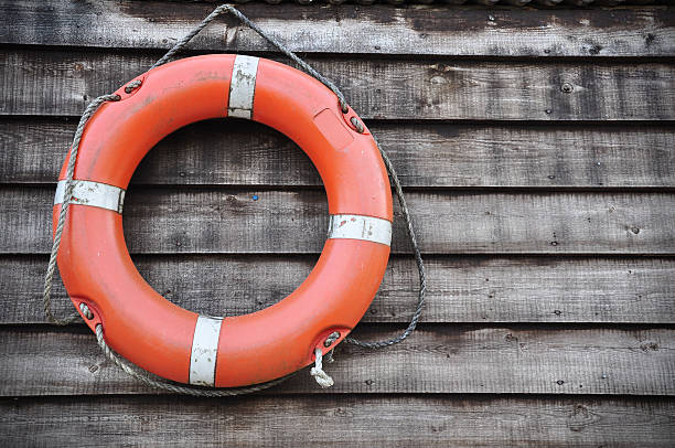 istock Orange Lifebuoy hanging on wood wall 93351695