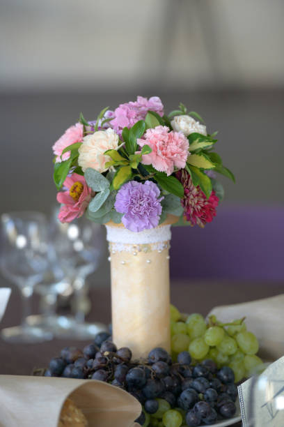 Wedding floral table arrangement with fresh carnations and grapes