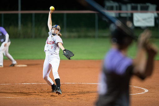 Female Softball Player in Mid Throw