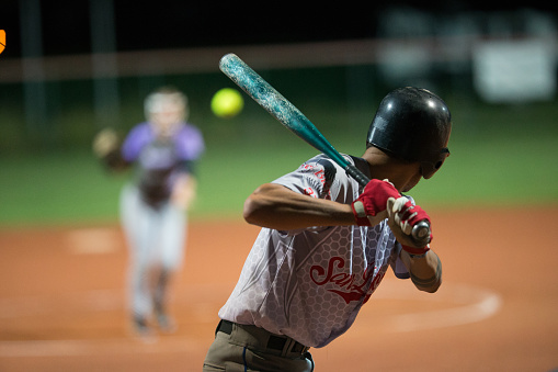 Rear View of a Softball Batter Preparing to Hit the Ball Mid Air