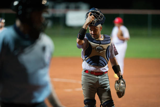 istock Softball Catcher Taking his Helmet Off 933528434
