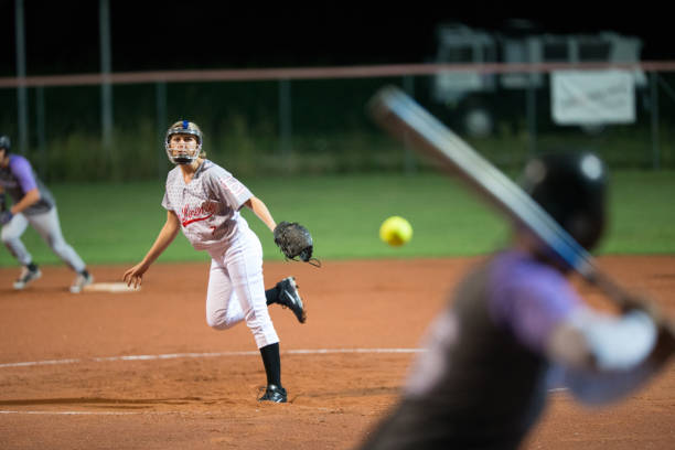 istock Softball Pitcher Throwing the Ball to Batter 933528436