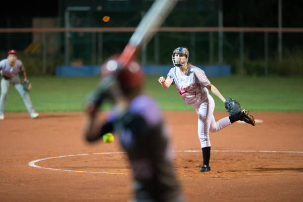 istock Softball Pitcher Throwing the Ball to Batter 933528438