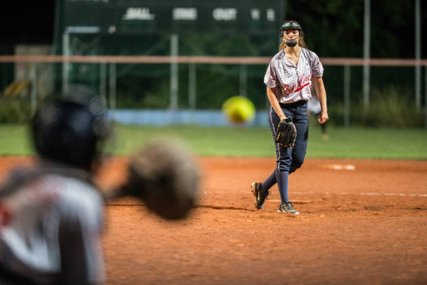 istock Softball Pitcher Looking at the Ball Mid Air 933529032
