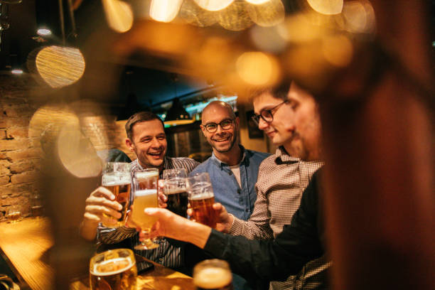 Smiling friends in a pub, toasting to their friendship