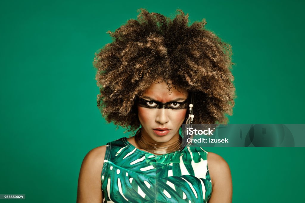 Fashion portrait of angry afro american young woman Summer portrait of angry afro american young woman, staring at camera. Studio shot, green background. Authority Stock Photo
