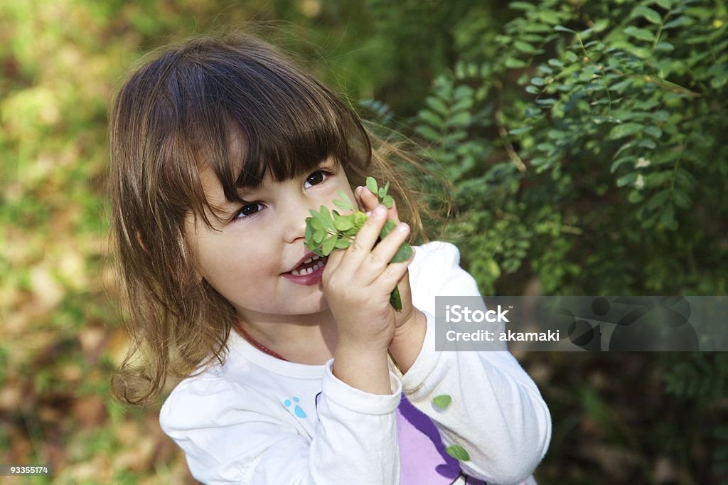 Jolie fillette heureuse tenant feuilles vertes - Photo de Activité libre de droits