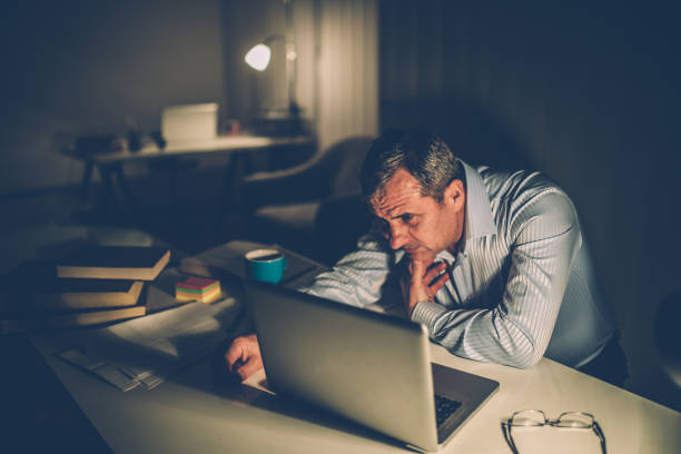 istock Tired businessman working late 933582800