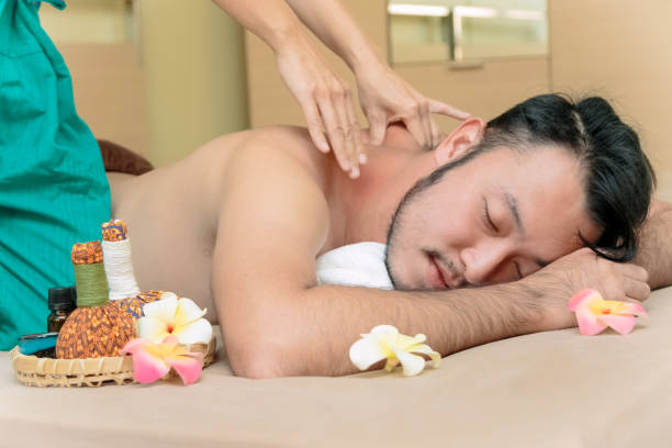 istock Happy Asian man lying on the massage table and smiling, spa concept 933583540