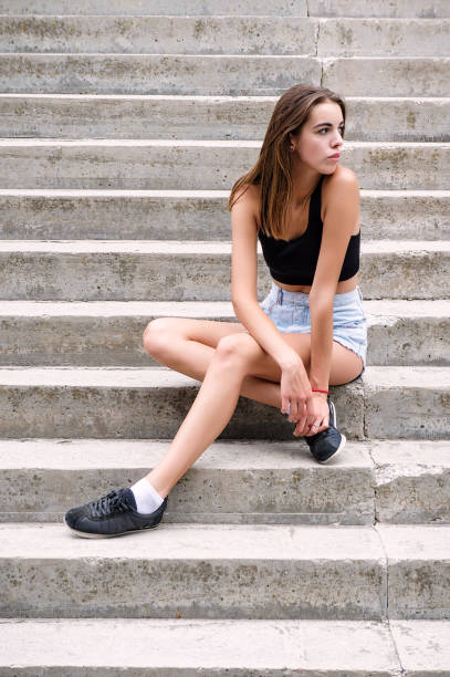 istock Young beautiful girl sitting on the stairs 933587122