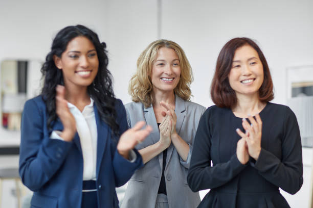 istock Smiling businesswomen applauding in office 933591026