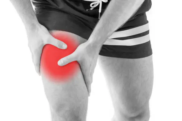 Man with quadriceps pain over white background