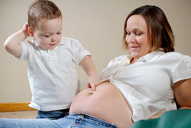 Pregnant mother and toddler stock photo