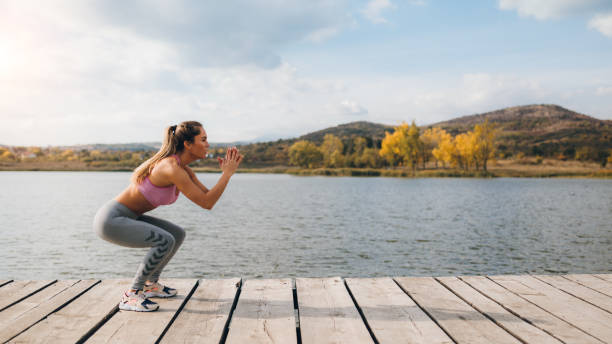 Fit young woman stretching at the lake