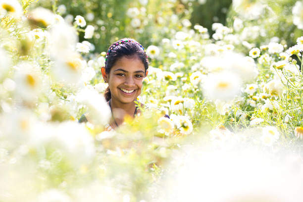 Happy Indian girl in field of daisy flowers