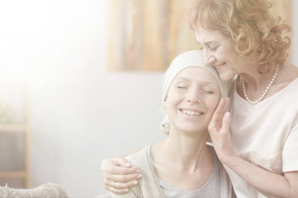 Photo with flare effect Bright photo with flare effect showing mother and daughter with cancer hugging and smiling bare bosom pic stock pictures, royalty-free photos & images