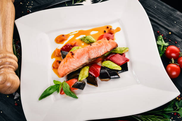 istock Baked Salmon Steak with Vegetables. On a wooden background. Top view. Copy space. 933633030