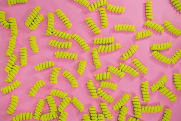 Top view of fusilli pasta on the bright pink background. Fashion food