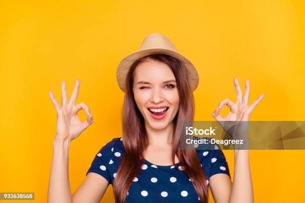 Portrait Of Sexy Charming Pretty Nice Trendy Laughing Girl In Polkadot Tshirt Showing Two Ok Sign With Fingers Blinking With Eye At Camera Isolated On Yellow Background Stock Photo - Download Image Now