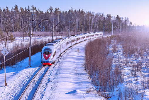 Modern high-speed train moves fast at winter morning time.