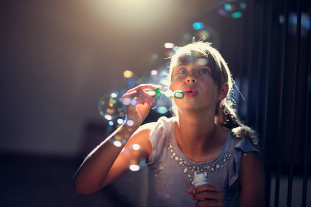 chica que se divierte soplando burbujas - bubble child bubble wand blowing fotografías e imágenes de stock