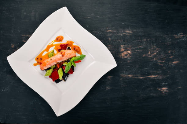istock Baked Salmon Steak with Vegetables. On a wooden background. Top view. Copy space. 933646926