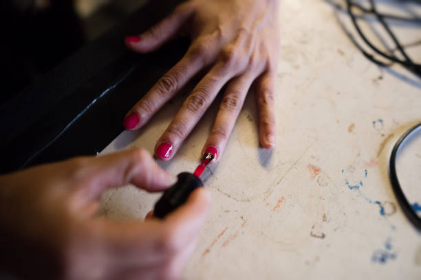 istock applying red nail polish in a theater 933647298