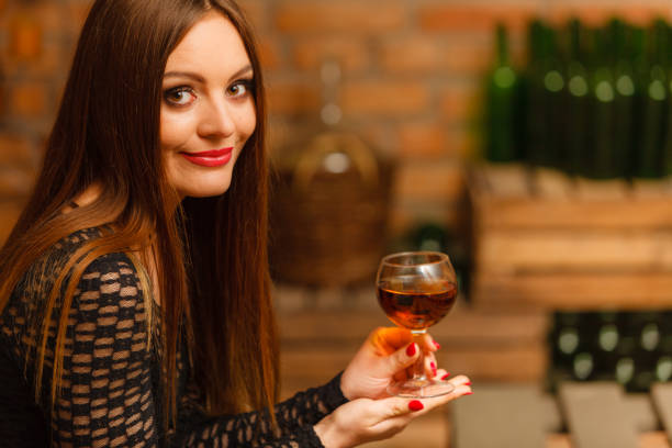 istock Woman tasting wine in rural cottage interior 933657530