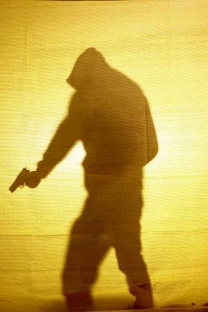 istock Shadow behind fabric of a man with a gun 933665002