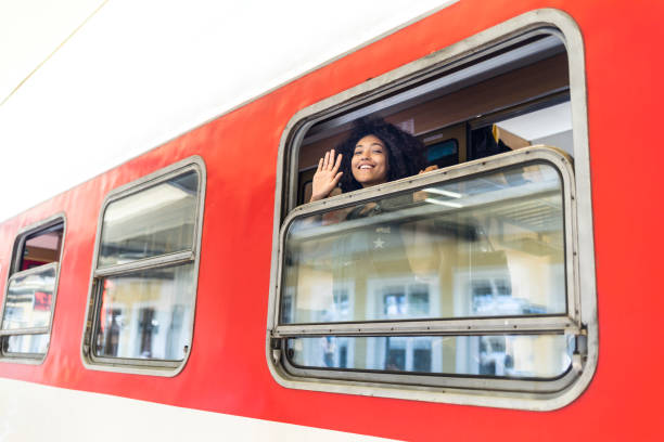 istock Woman waving hand through train window 933665356