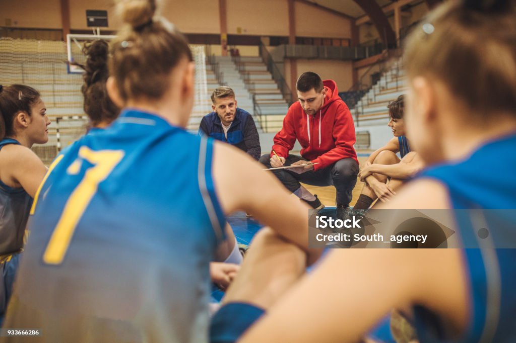 Coach talking to players Group of women listening their coach on the floor before basketball training. Coach Stock Photo