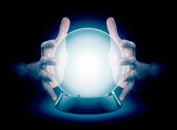 Hands On Crystal Ball And Cryptocurrency A pair of male hands surrounding a crystal ball conjuring up a hologram on an isolated dark studio background crystal ball photos stock pictures, royalty-free photos & images
