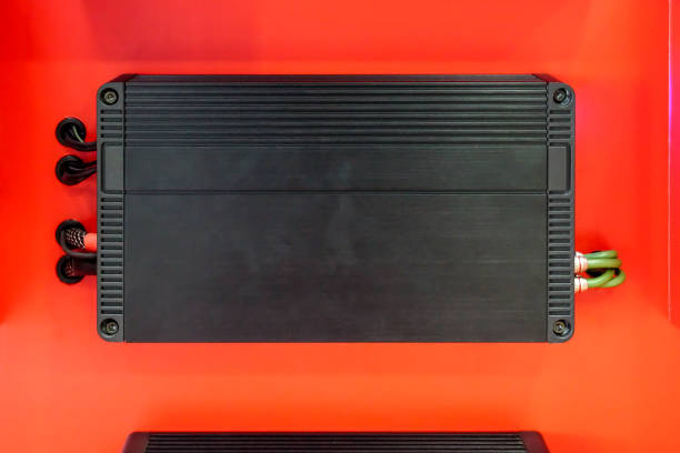 istock Car audio amplifier with cables isolated on red background 933669784