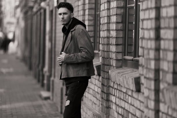 istock Model looking man stand near the wall and look on his watch 933670088