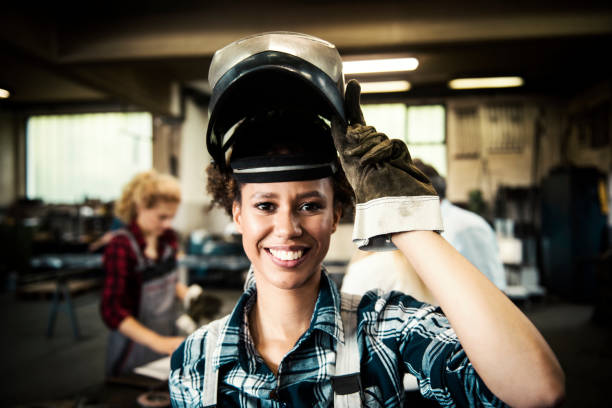 weibliche schweißer in ein metall-shop - welder manual worker african descent steel worker stock-fotos und bilder