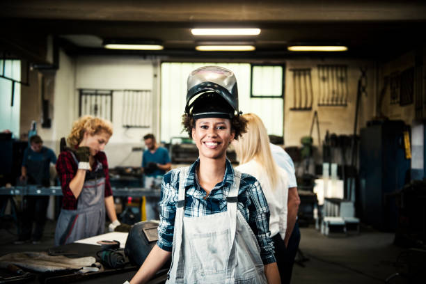 weibliche schweißer in ein metall-shop - welder manual worker african descent steel worker stock-fotos und bilder