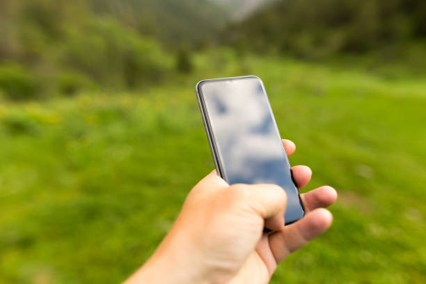 istock Black cell phone in a hand outdoors 933670996