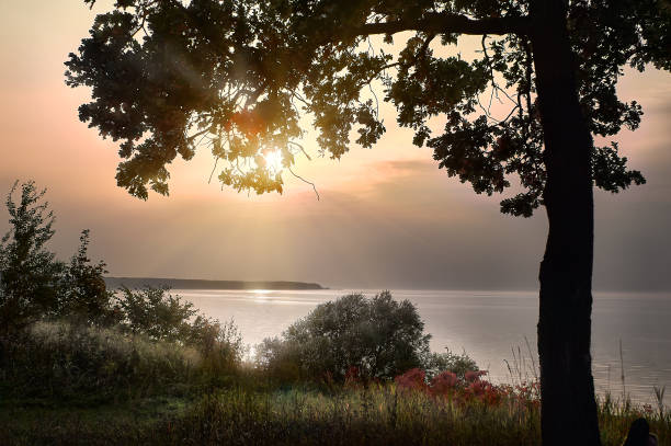 istock Autumn is joy, or sadness? Rays of the setting sun over the Volga river (Russia) 933679432