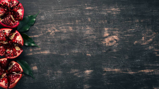 istock Fresh pomegranate. On a black wooden background. Top view. Copy space. 933681748