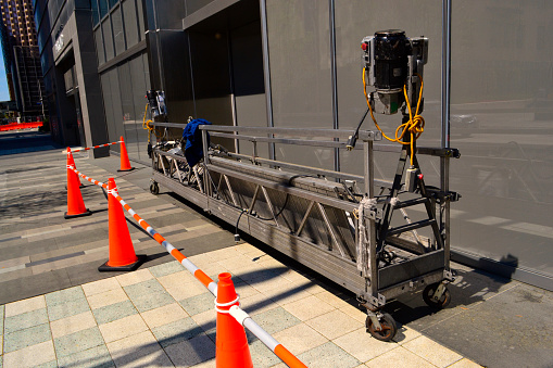 Building maintenance workers cradle. Maintenance workers use this lift to do dangerous work on building exteriors often at extreme heights.