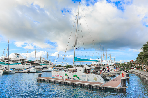 Tahiti, French Polynesia – March 18, 2018 :  The sailing boat park in sunset time at Large seaport in Tahiti PAPEETE, FRENCH POLYNESIA.