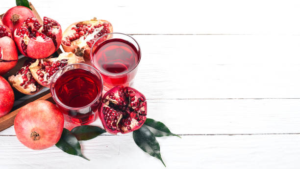 istock Fresh pomegranate juice. Pomegranate. On a white wooden background. Top view. Copy space. 933700330