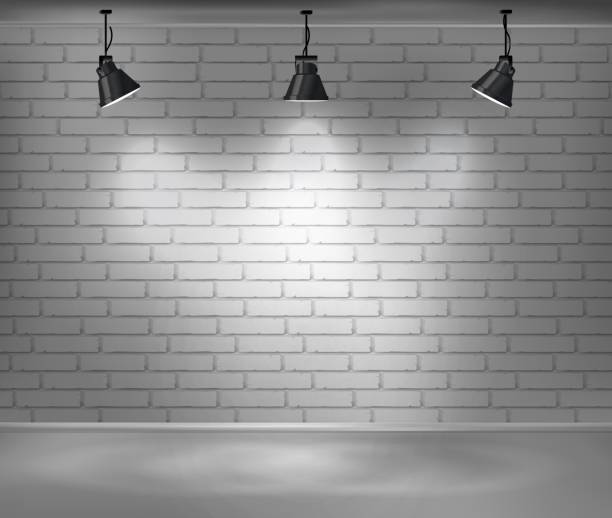 istock Empty brick wall. Blank room is illuminated by three lamps. Background for advertising indoors. 933712208